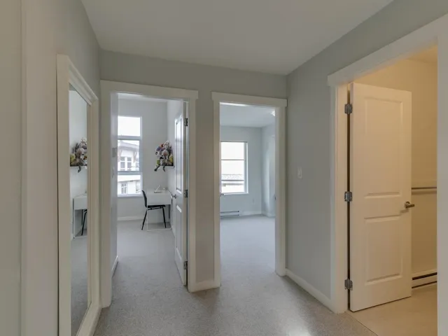 Hall with light carpet and a baseboard radiator