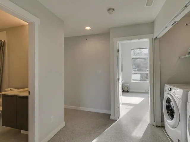 Laundry room with light colored carpet, washing machine and dryer, and recessed lighting