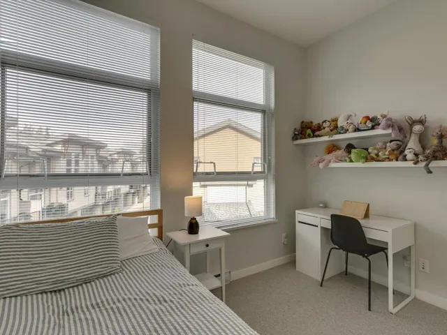 Bedroom featuring light carpet and baseboards