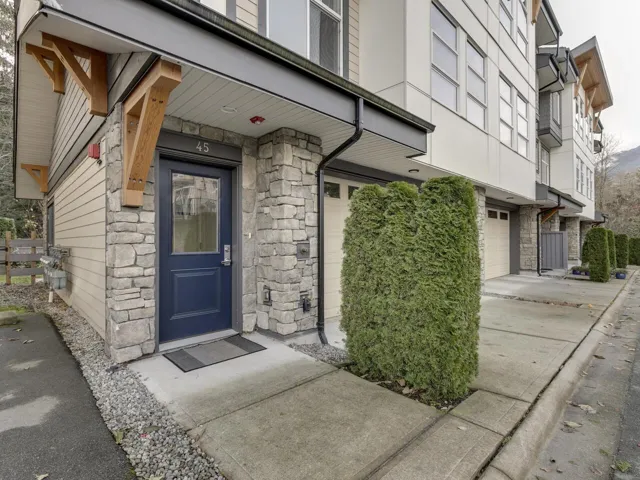 View of exterior entry featuring stone siding and an attached garage