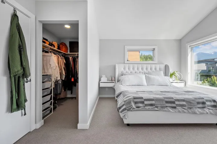 Carpeted bedroom featuring a spacious closet, vaulted ceiling, a closet, and recessed lighting