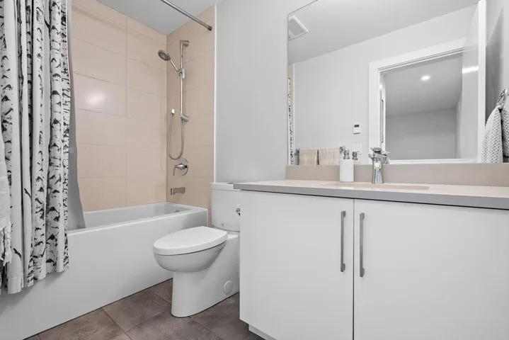 Full bathroom featuring shower / bathtub combination with curtain, vanity, and tile patterned flooring