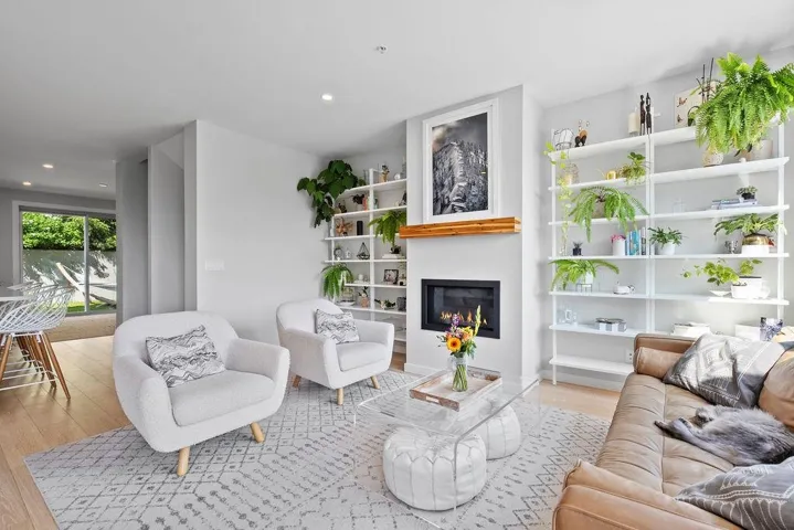 Living area featuring wood finished floors, a glass covered fireplace, and recessed lighting