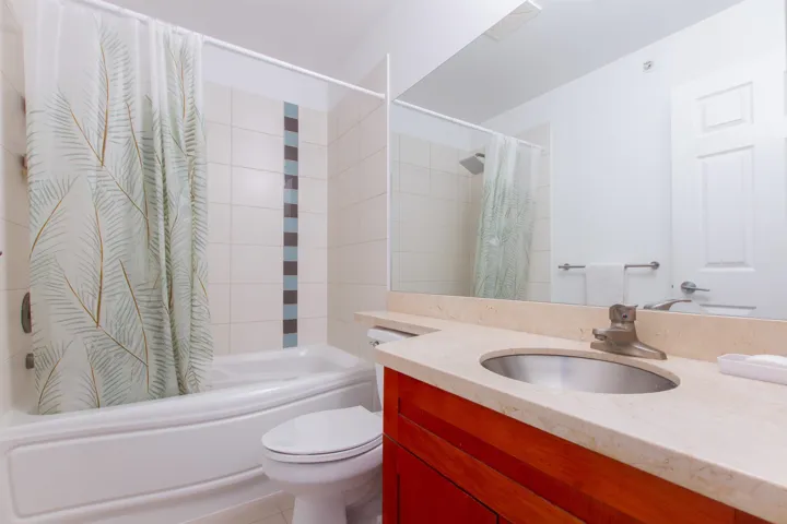 Full bathroom featuring toilet, shower / bathtub combination with curtain, and vanity