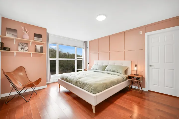 Bedroom with a decorative wall and hardwood / wood-style flooring