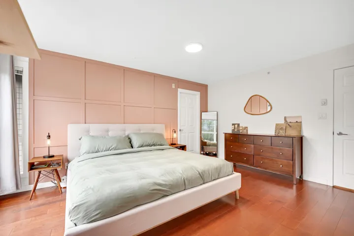 Bedroom featuring a decorative wall and wood finished floors