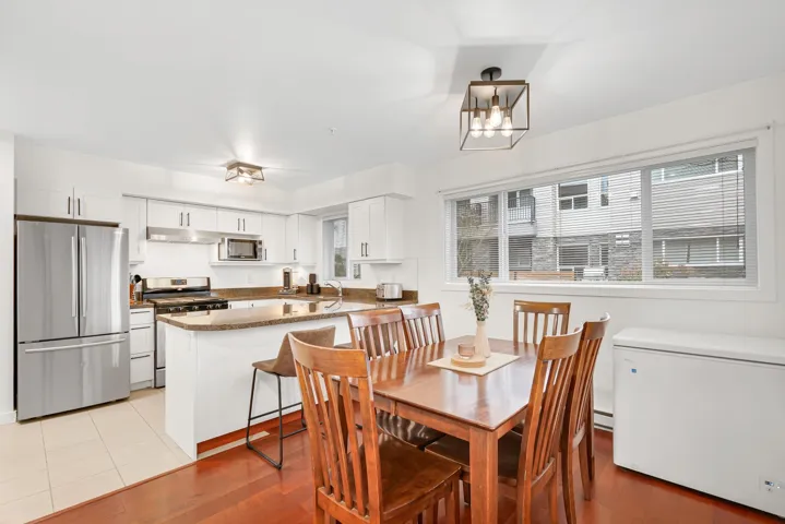 Dining space with a chandelier, a baseboard heating unit, and light wood-style floors