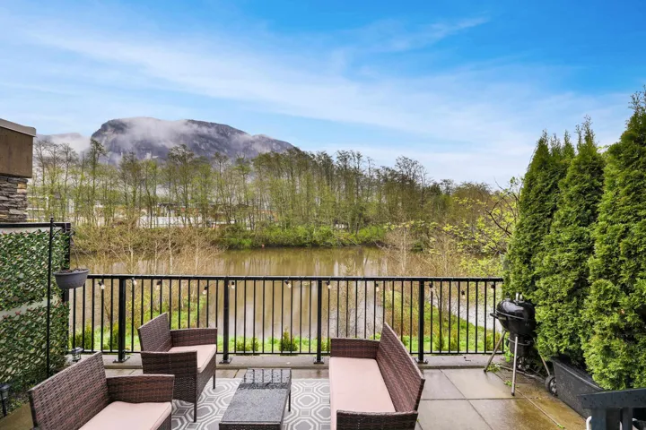 View of patio with grilling area, an outdoor living space, a water and mountain view, and a balcony