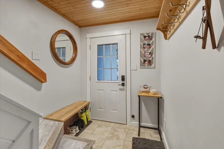 Doorway to outside with wooden ceiling and tile patterned flooring
