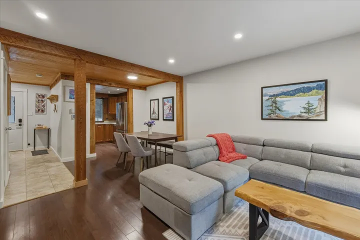 Living area with wood-type flooring, recessed lighting, and beam ceiling