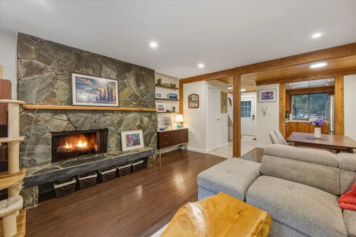 Living room featuring a stone fireplace and wood finished floors