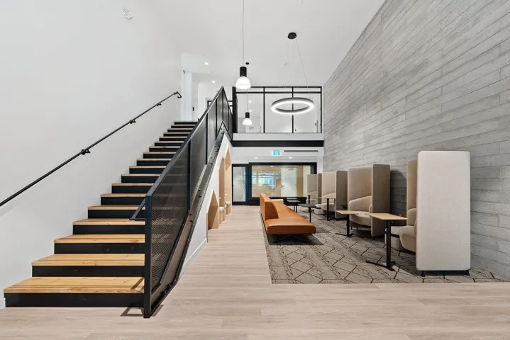 Wide staircase featuring wood treads and black metal railings