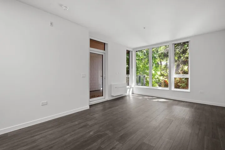 Bright room with wood-finish flooring and multiple large windows