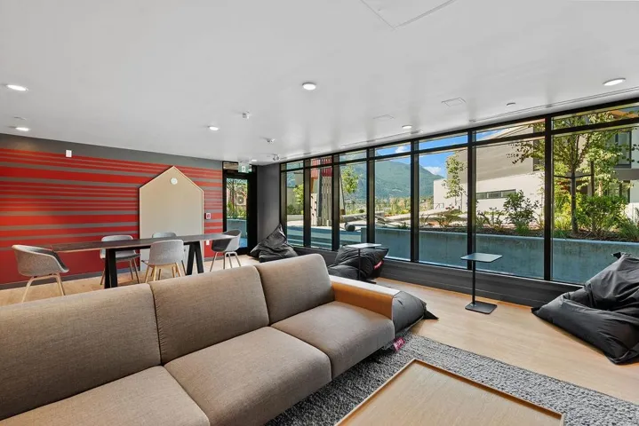 Spacious common area featuring large format windows, recessed lighting, wood-finish flooring, and a decorative accent wall