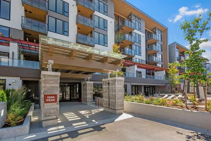 Contemporary multi-story building featuring a prominent stone and wood entry canopy