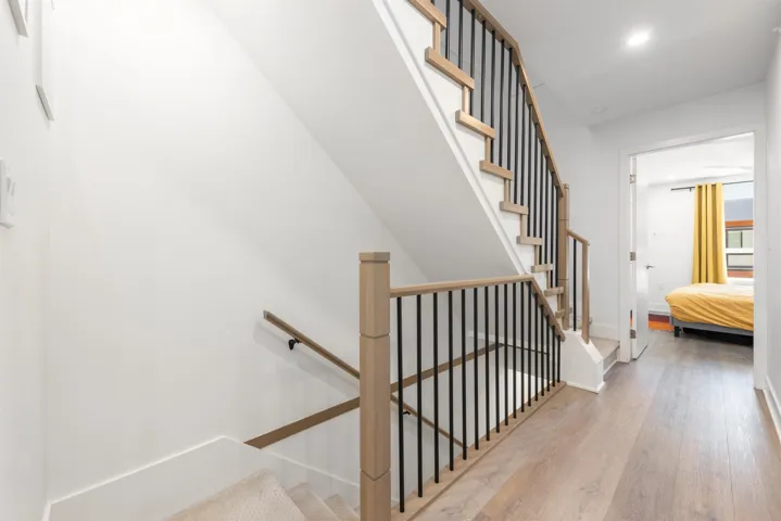 Stairs featuring wood finished floors and recessed lighting
