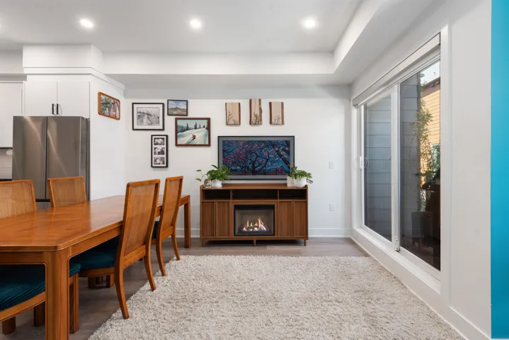 Dining room featuring recessed lighting, wood finished floors, and a lit fireplace