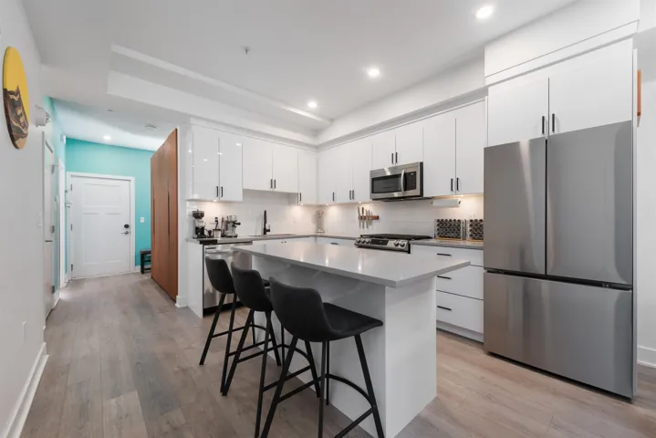 Kitchen featuring appliances with stainless steel finishes, a kitchen bar, tasteful backsplash, a center island, and recessed lighting