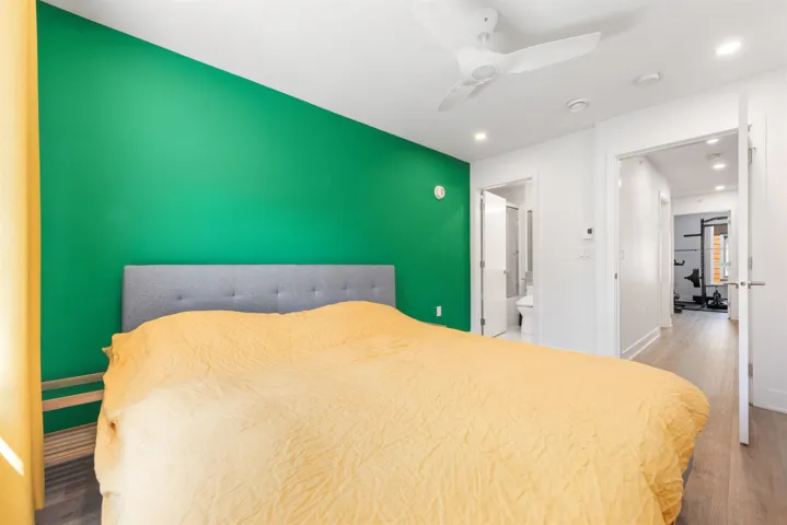 Bedroom featuring wood finished floors, recessed lighting, ceiling fan, and ensuite bathroom