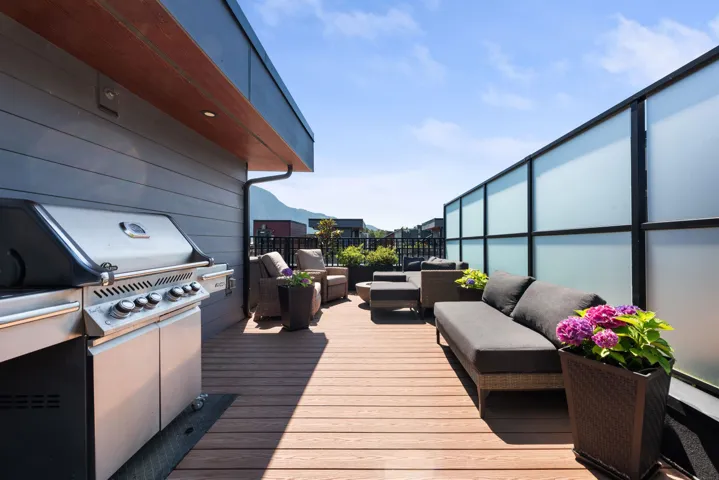 Deck with an outdoor hangout area and area for grilling