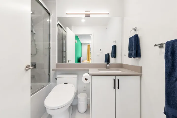 Full bathroom featuring vanity and bath / shower combo with glass door