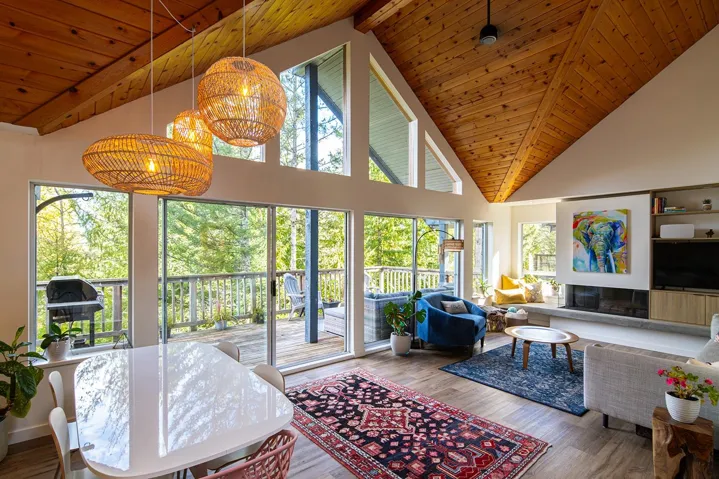 Living room with wood finished floors, high vaulted ceiling, and a wood ceiling with exposed beams