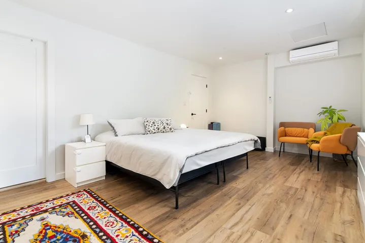 Bedroom with light wood-style flooring, recessed lighting, a wall mounted air conditioner, and attic access