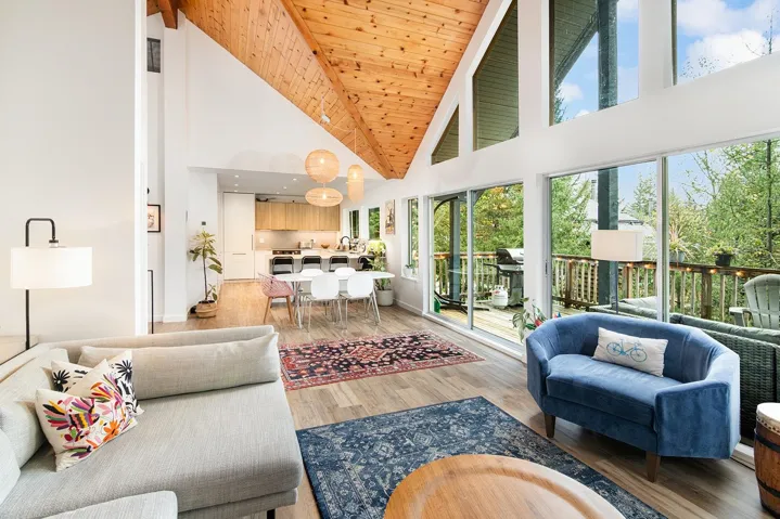 Living room with high vaulted ceiling, light wood-type flooring, and a wood ceiling with exposed beams