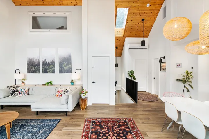 Living area featuring high vaulted ceiling, wooden ceiling, wood finished floors, and a wall mounted AC