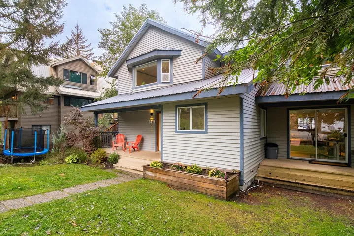 View of front of house featuring a trampoline, a metal roof, and a front lawn