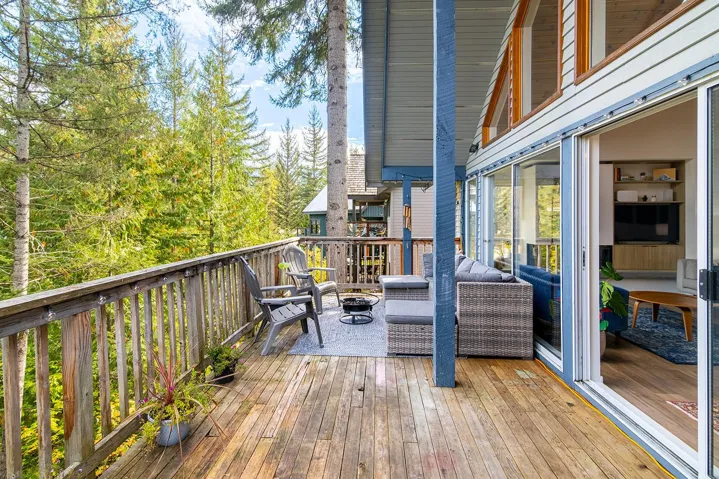Wooden terrace featuring an outdoor fire pit and view of scattered trees
