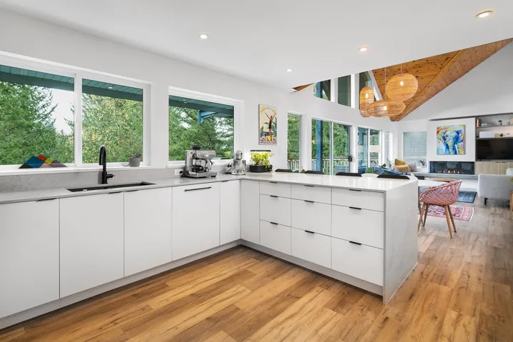Kitchen featuring modern cabinets, white cabinetry, light stone counters, recessed lighting, and hanging light fixtures