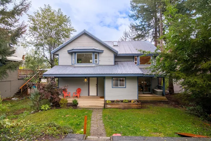 View of front of home with a front yard, a metal roof, and covered porch