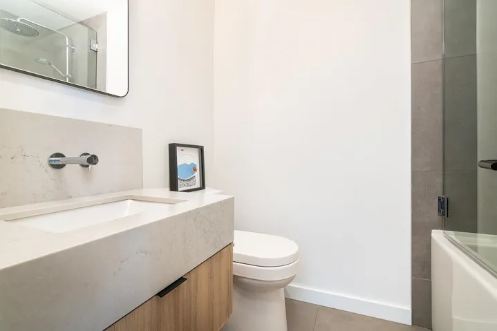 Full bath with vanity, light tile patterned floors, and enclosed tub / shower combo