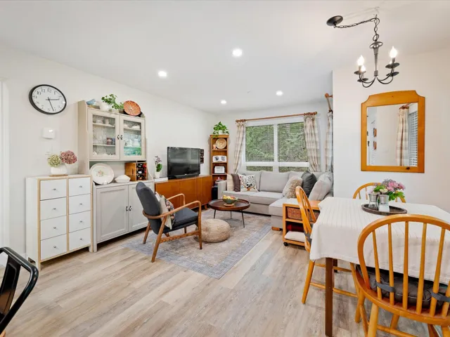 Living room featuring light wood-style floors, recessed lighting, and a chandelier