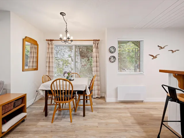 Dining area with a chandelier, light wood-style flooring, and baseboards