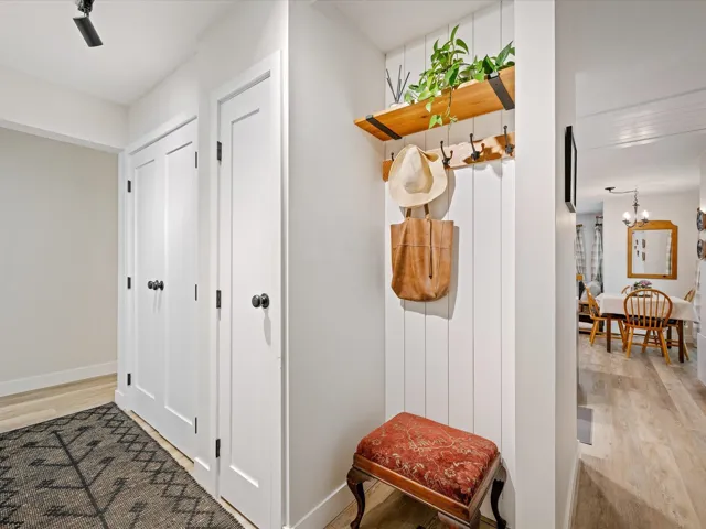 Mudroom with light wood-type flooring, a chandelier, and baseboards