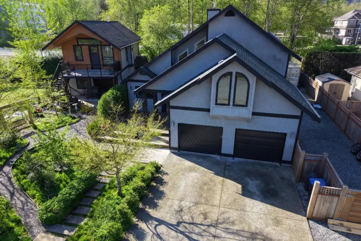 Contemporary stucco exterior with a two-car garage, arched window features, and dark trim accents