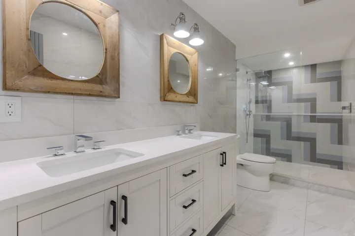 Full bath with tile walls, double vanity, a walk in shower, recessed lighting, and light marble finish flooring