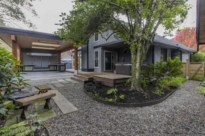 Rear view of house featuring a hot tub and a patio area