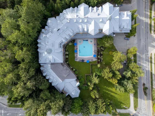 Expansive property featuring a large swimming pool with integrated hot tub, surrounding paved patio, and manicured lawns