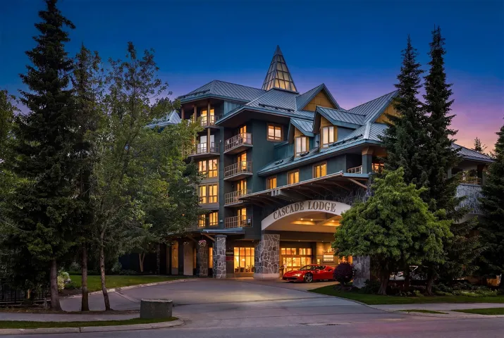 Multi-story building featuring a prominent gabled roofline with a central spired architectural element