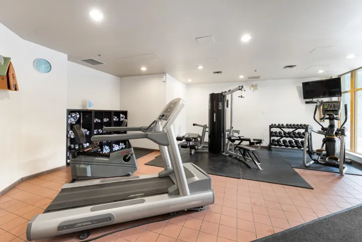 Fitness center featuring a tiled floor, white walls, and recessed lighting