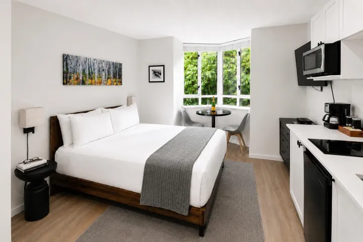 Compact studio space featuring wood-finish flooring and a bay window