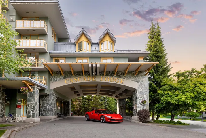 Stone-clad porte-cochère entrance with prominent "CASCADE LODGE" signage