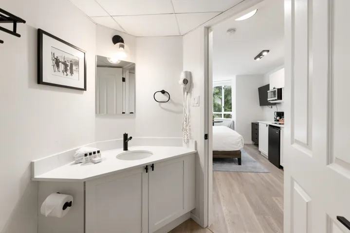 Bathroom vanity featuring a solid surface countertop with an integrated sink and matte black faucet