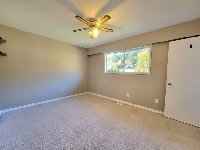 Spare room with light colored carpet and a ceiling fan