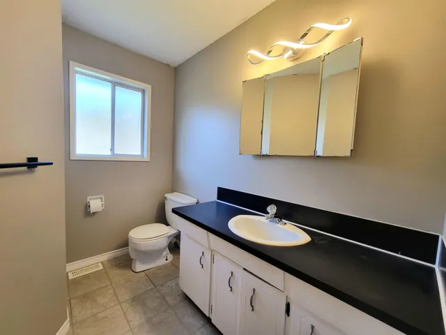 Half bath with vanity and light tile patterned floors