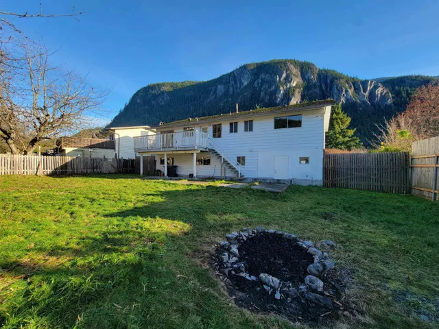 Back of property with stairs, a fenced backyard, a patio, a fire pit, and a deck with mountain view