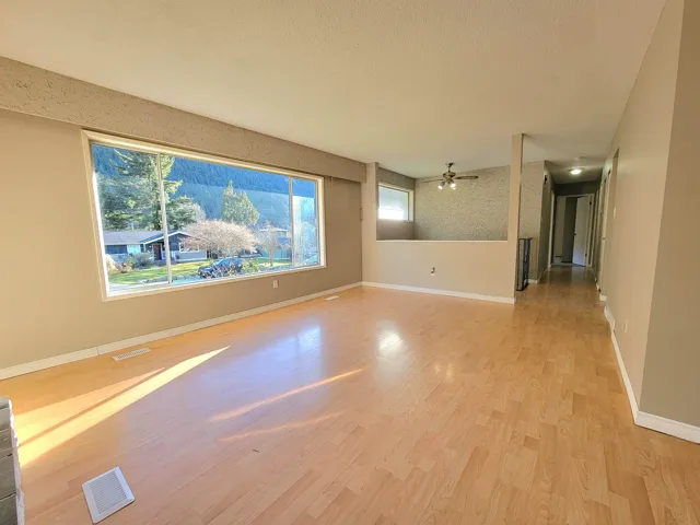 Spare room featuring light wood-style flooring, ceiling fan, and a textured ceiling